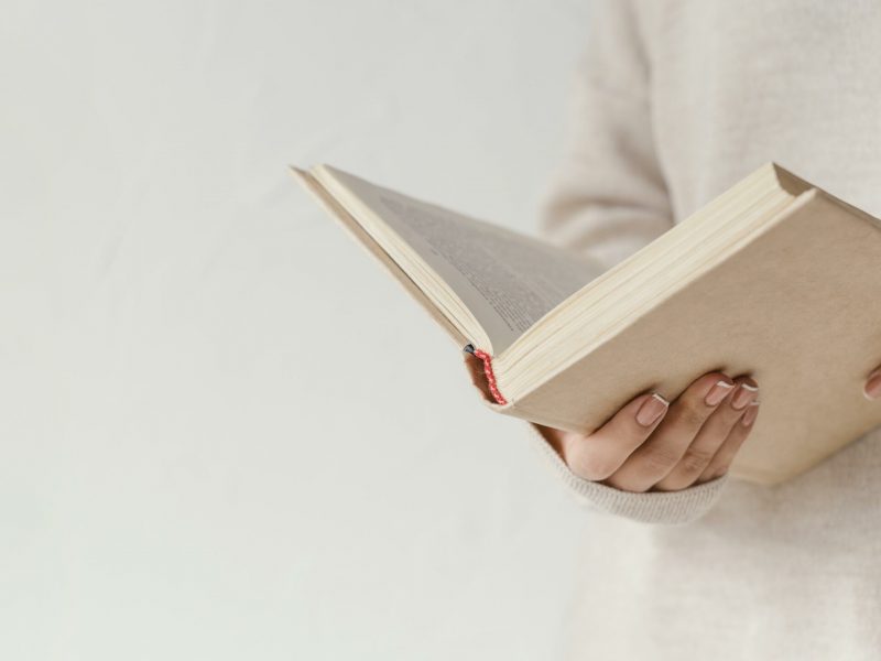 close-up-hands-holding-open-book